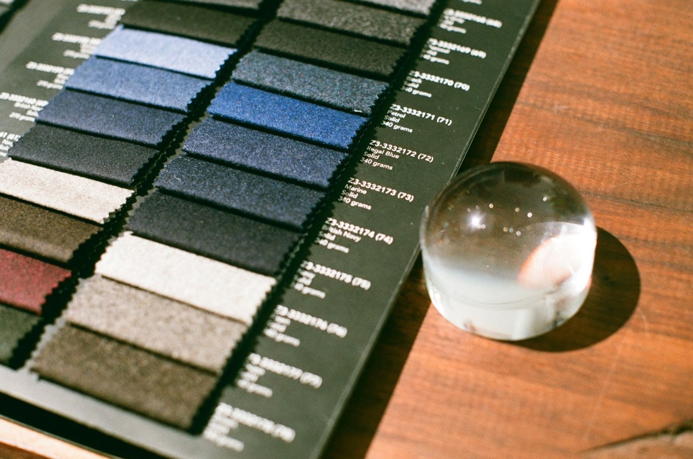Swatches of fabric in blue, gray and cream fanned out on a table